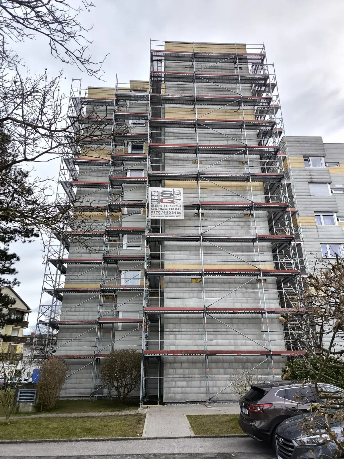 Wohnblock mit Fassadengerüst und Sentesch-Banner