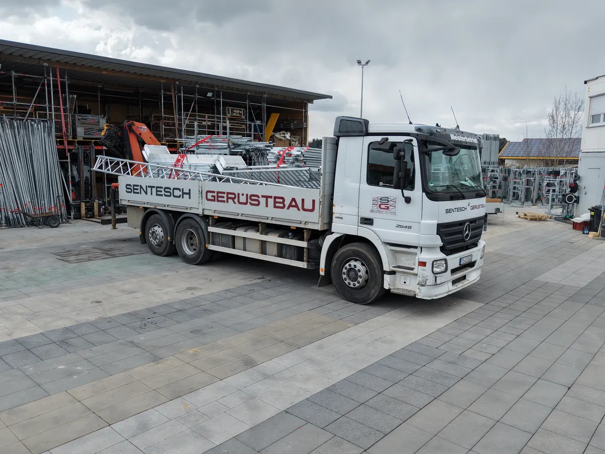 Gerüstbau-LKW mit Kran beim Beladen
